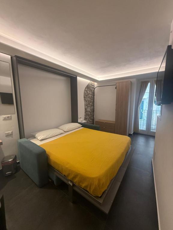 a bedroom with a bed with a yellow blanket at Alley House in Cefalù