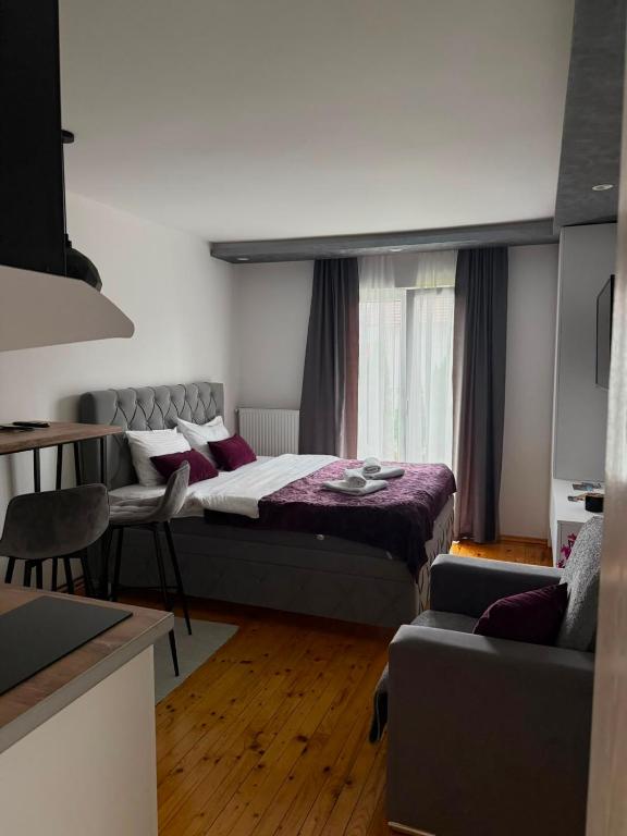 a bedroom with a bed and a couch at Apartman Ena in Nova Varoš