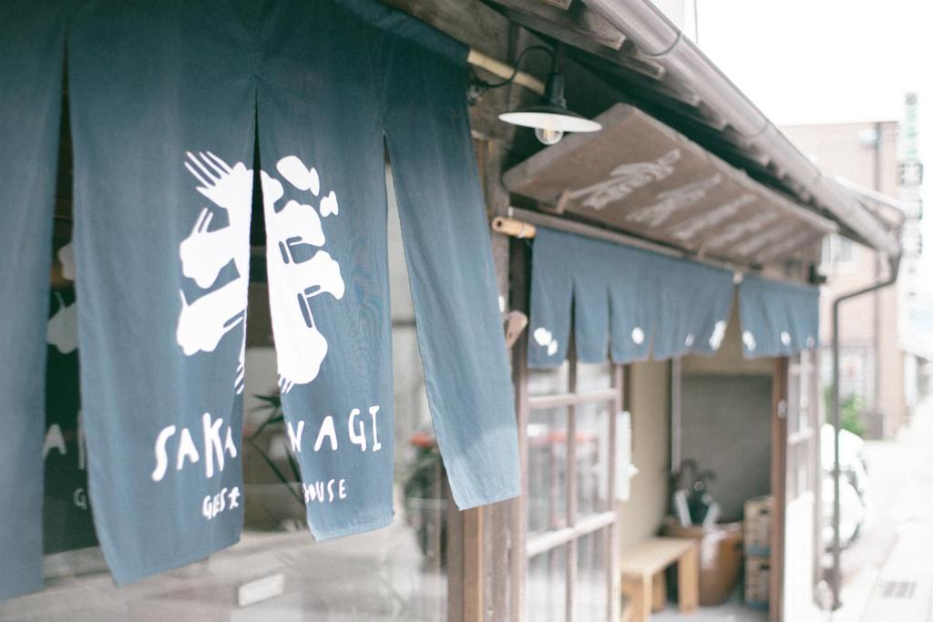 a building with blue and white signs on it at サカナギゲストハウス in Nagano