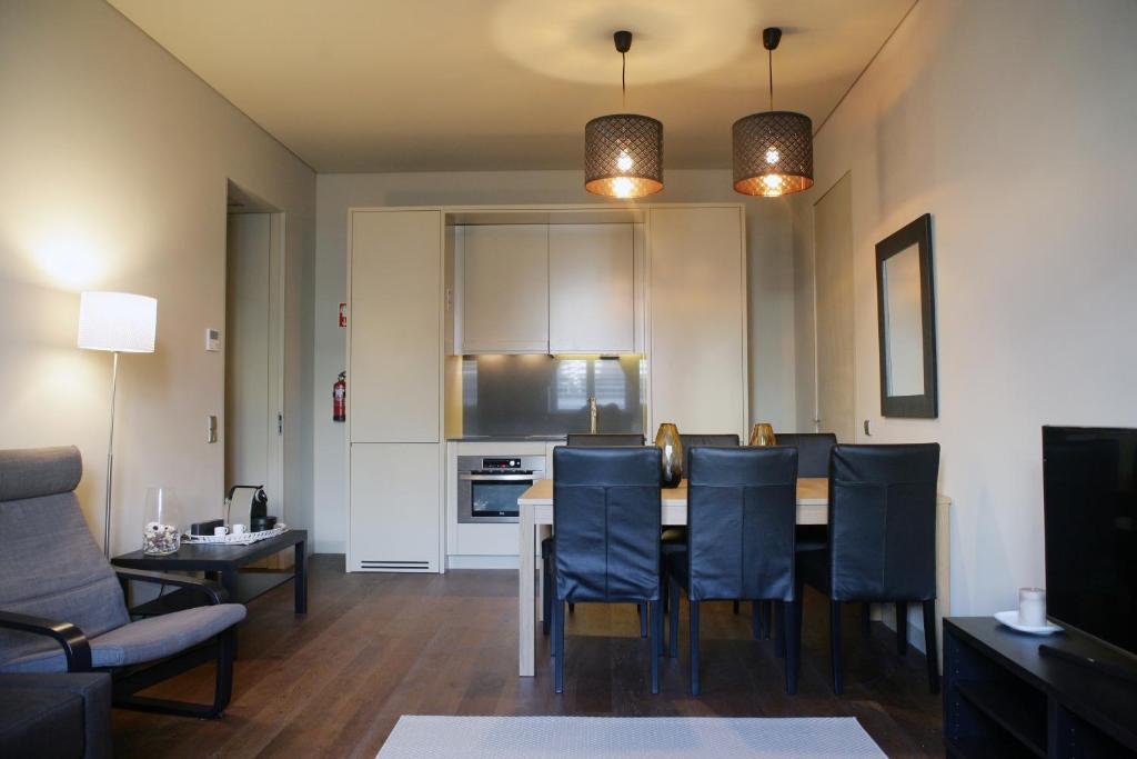 Il comprend une cuisine et un salon avec une table et des chaises. dans l'établissement Mercado da Ribeira 5 Stars Apartment, à Lisbonne