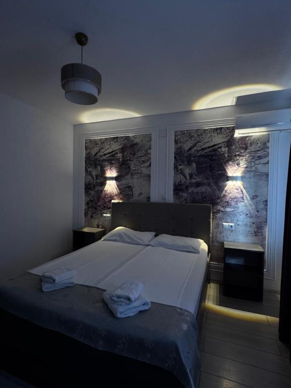 a bedroom with a bed with two towels on it at Vila Adelin in Tăşnad