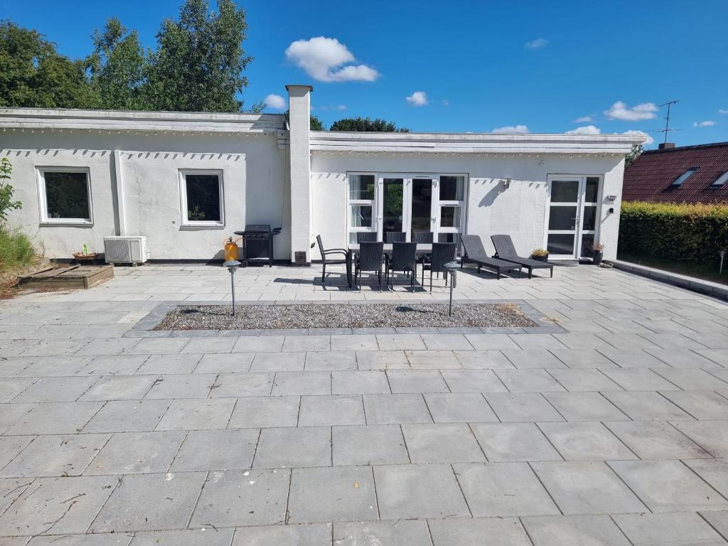 a patio in front of a white house at Det lille hus in Viborg