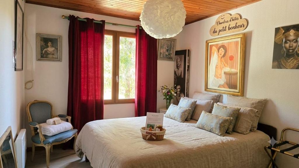 a bedroom with a large bed with red curtains at Chambres Du Petit Bonheur in Biscarrosse