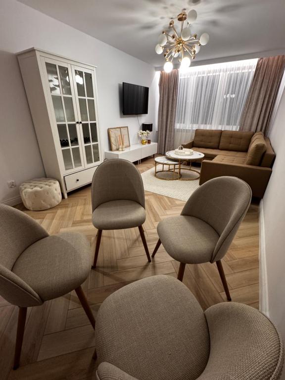 a living room with three chairs and a couch at Apartament Piękna in Łomża