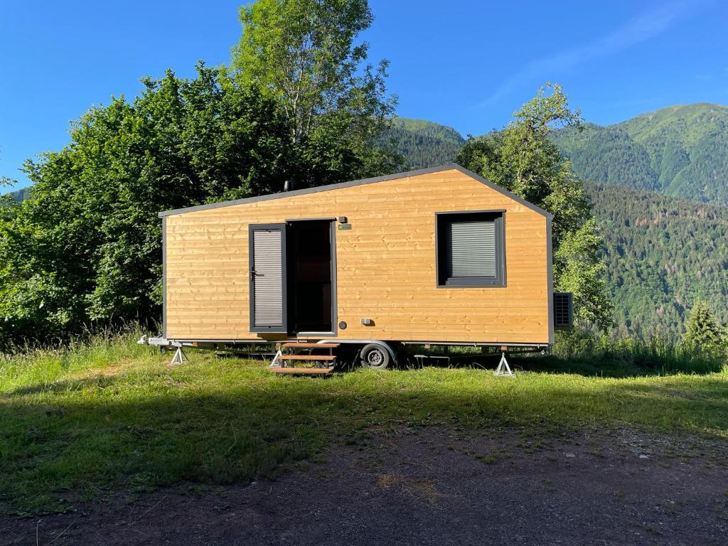 a tiny house sitting on top of a field at Tiny House Luc in Prato Carnico