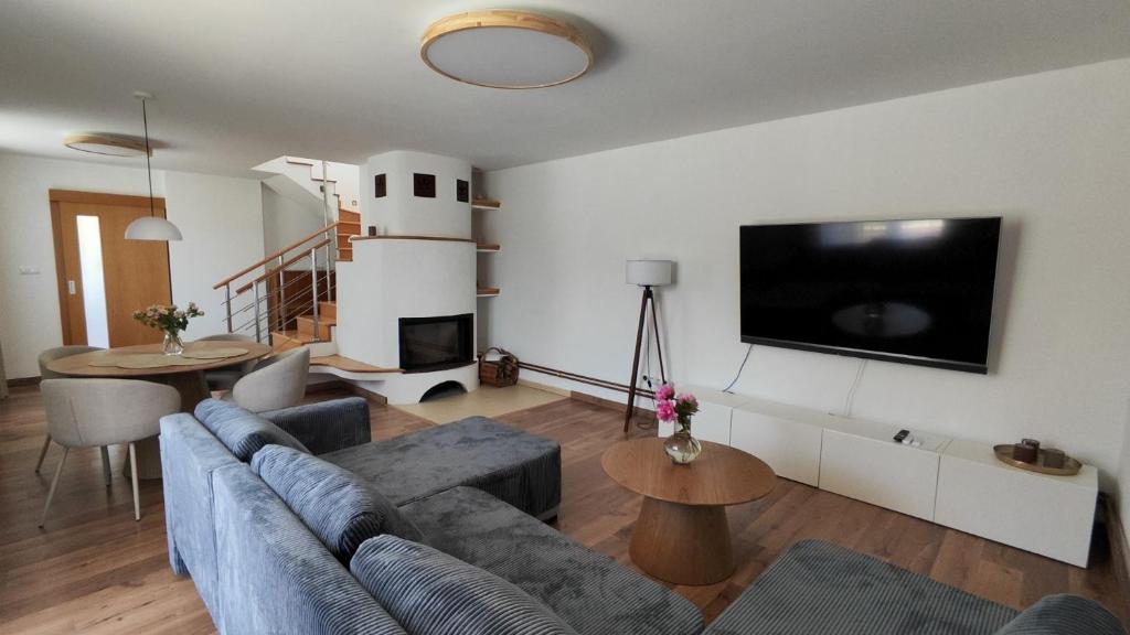 a living room with a couch and a flat screen tv at Sunrise House in Žilina