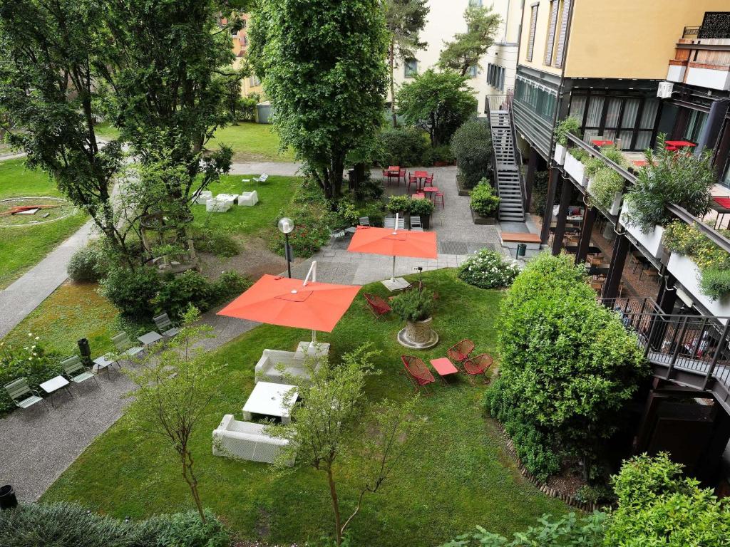 an aerial view of a garden with orange umbrellas at Mercure Bologna Centro in Bologna