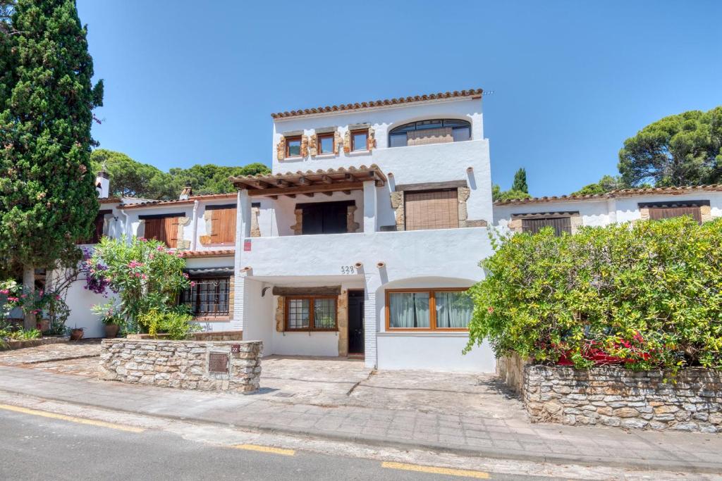 a white house with a stone wall at Pescadors in Pals