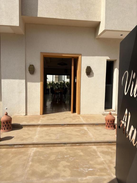 a entrance to a building with a table and chairs at Riad Villa Alain in Nouaceur