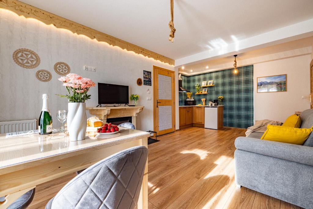 a living room with a couch and a table at Apartamenty pod Góralskim Niebem in Gliczarów Górny
