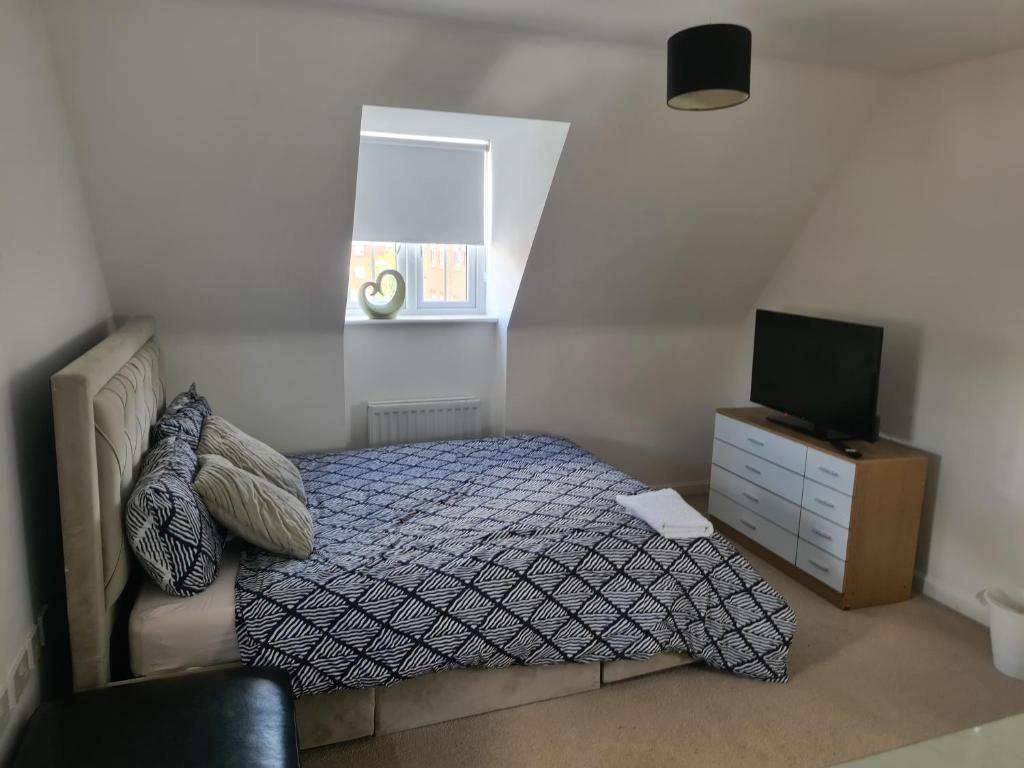 a bedroom with a bed and a tv on a dresser at FV Dwelling in Hucknall
