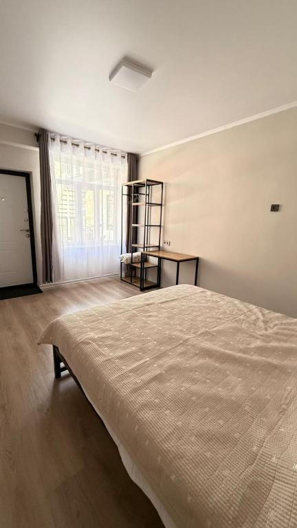 a bedroom with a large bed and a window at Aydin Guest House in Bayetovka