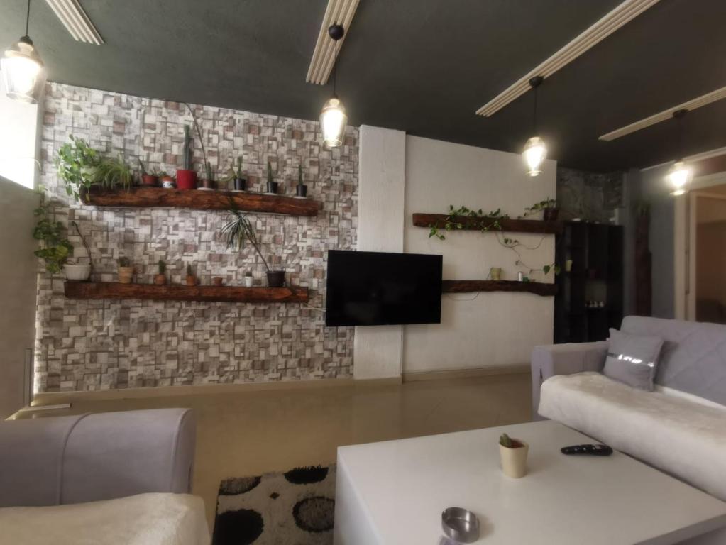 a living room with a couch and a tv at PRISHTINA Stay in Prishtinë