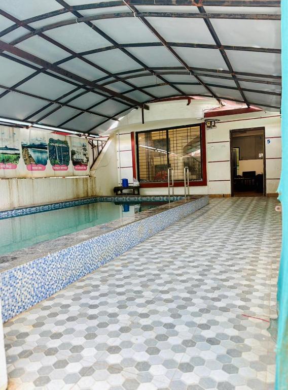 an empty swimming pool in a building with a swimming pool at 7 Stone in Malavli