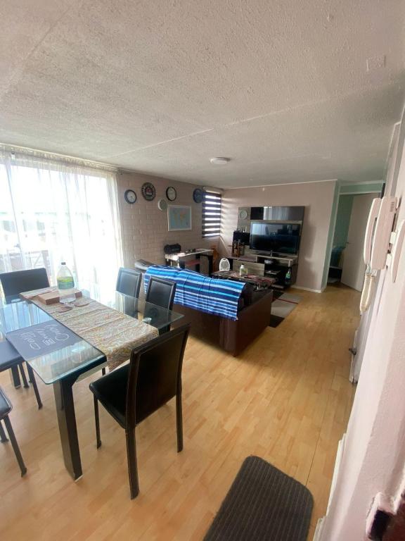 a living room with a table and a dining room at Comfortable apartment steps from Portal Belloto in Quilpué