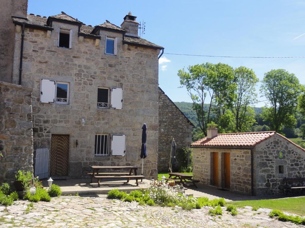 a stone building with a picnic table and a bench at Gite les ducs in Mialanes
