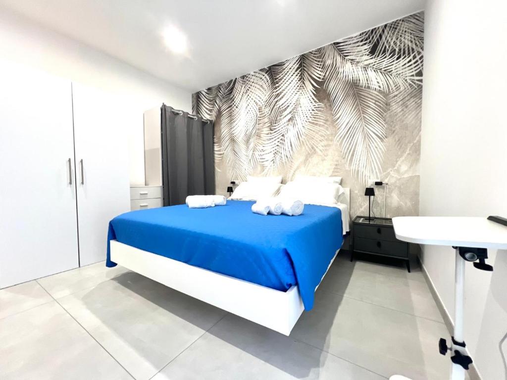 a bedroom with a blue and white bed and a sink at La Pola House Cagliari in Cagliari
