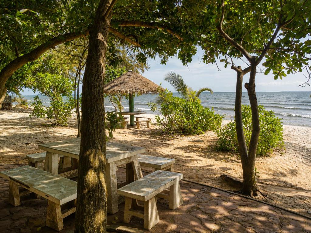 a picnic table on the beach next to the ocean at Oceanside Place in Rayong