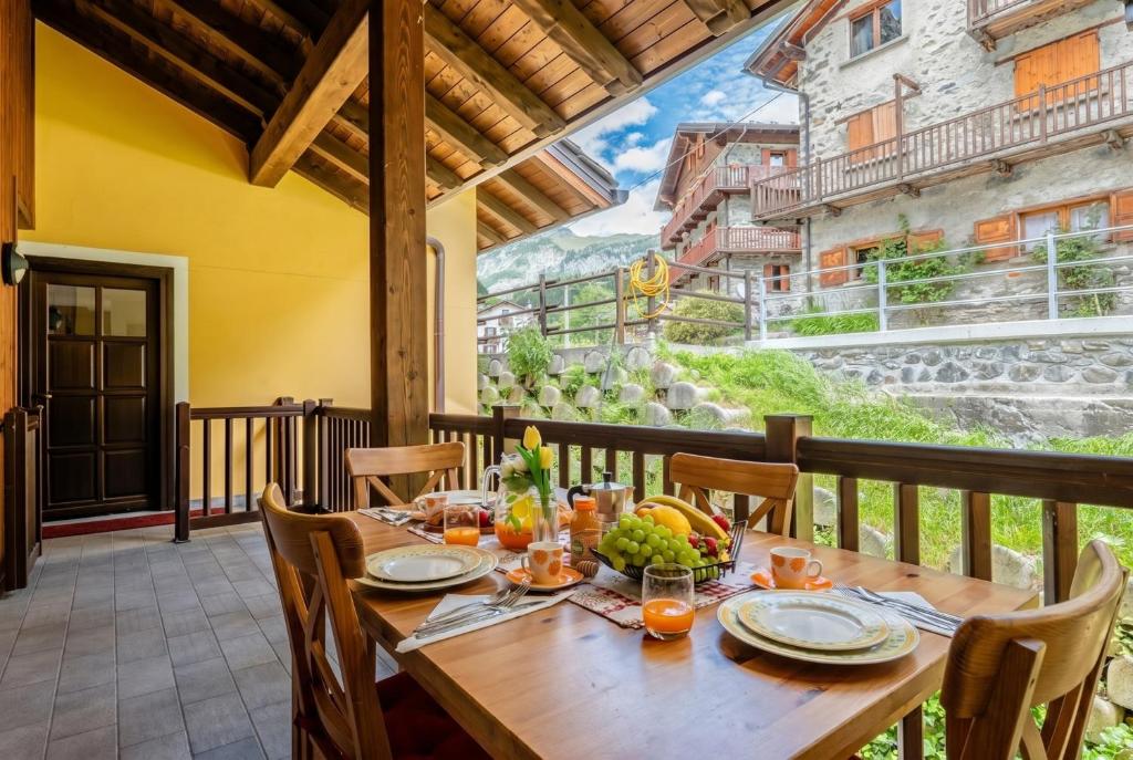a wooden table on a balcony with a meal on it at The Haven Quiet Escape - Panoramic Terrace in Valtournenche