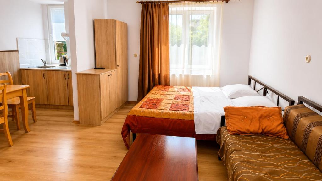 a hotel room with a bed and a couch at Tuz House R3 in Bakuriani