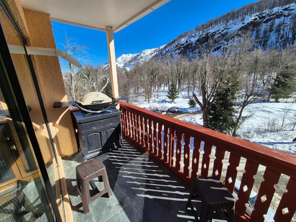a balcony with a grill and a snow covered mountain at Depto Premium Ski-in Ski-out Edificio Alerces-Nevados de Chillán in Nevados de Chillan