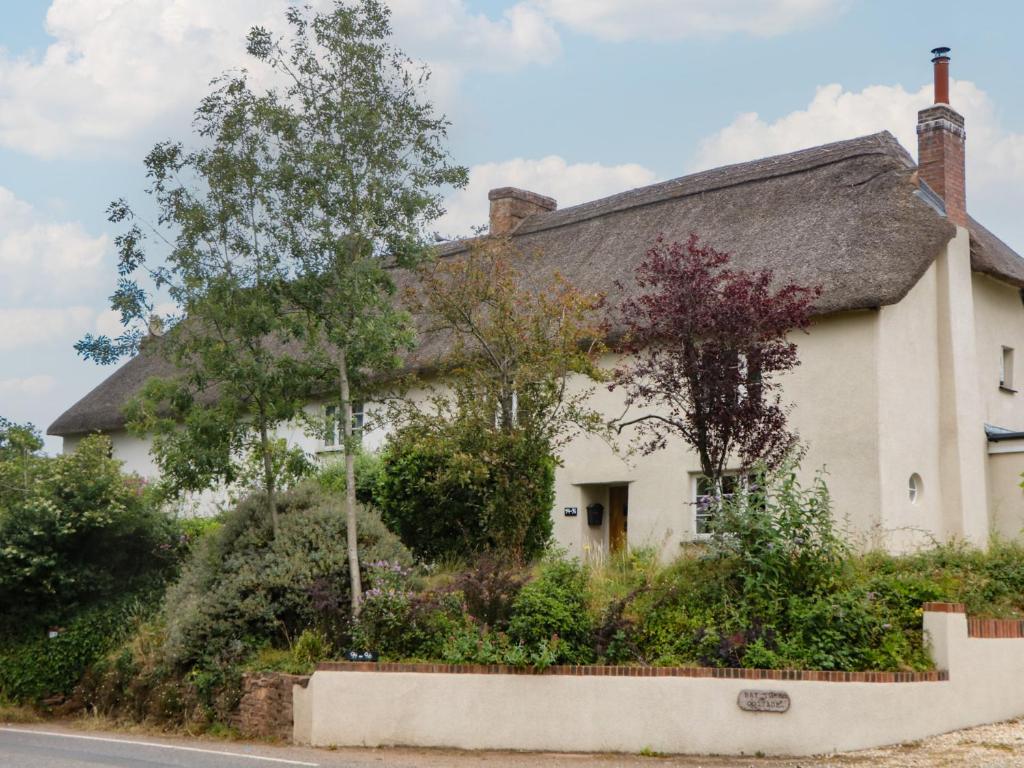 an old white house with a thatched roof at Mei's Cottage in Exeter