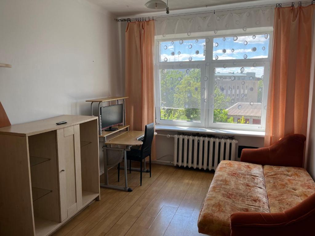 a living room with a desk and a window at Budget Room Vilnius in Vilnius