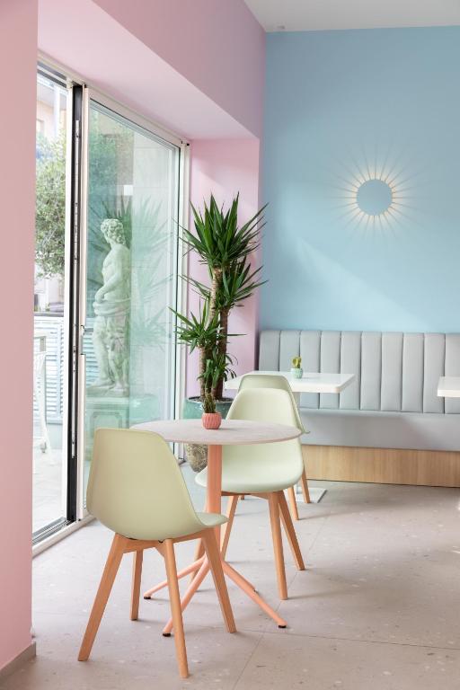 a room with a table and chairs and a plant at Hotel Majorca in Gabicce Mare