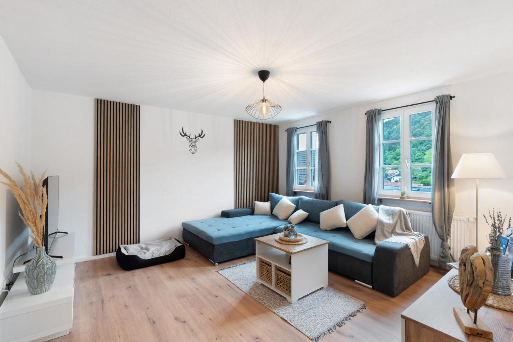 a living room with a blue couch and a table at Ferienhaus Bühlertal mit 3 Fewos in Bühlertal
