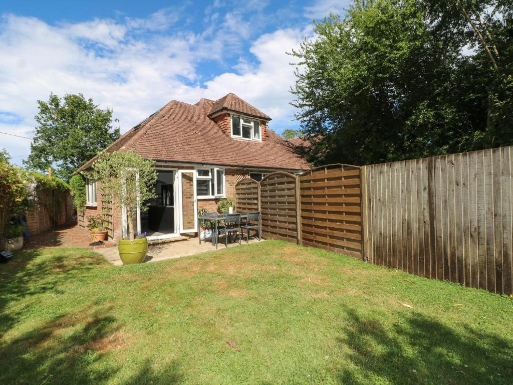 a backyard with a wooden fence and a wooden table at Lucerne Cottage in Dorking