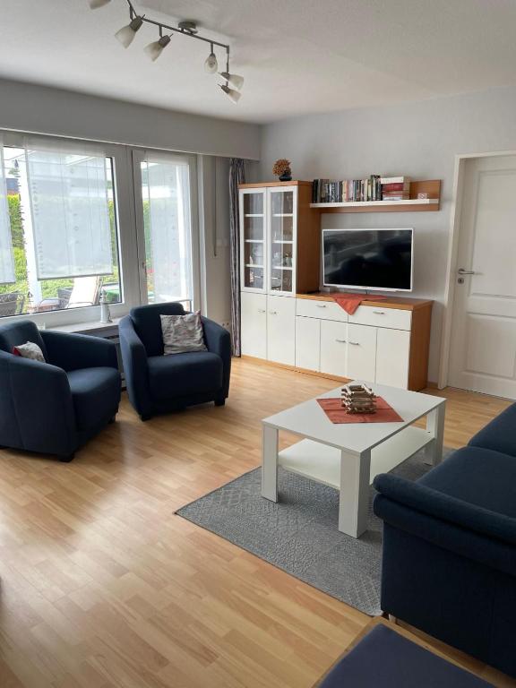 a living room with two blue couches and a coffee table at Ferienhaus Wind & Welle in Norddeich