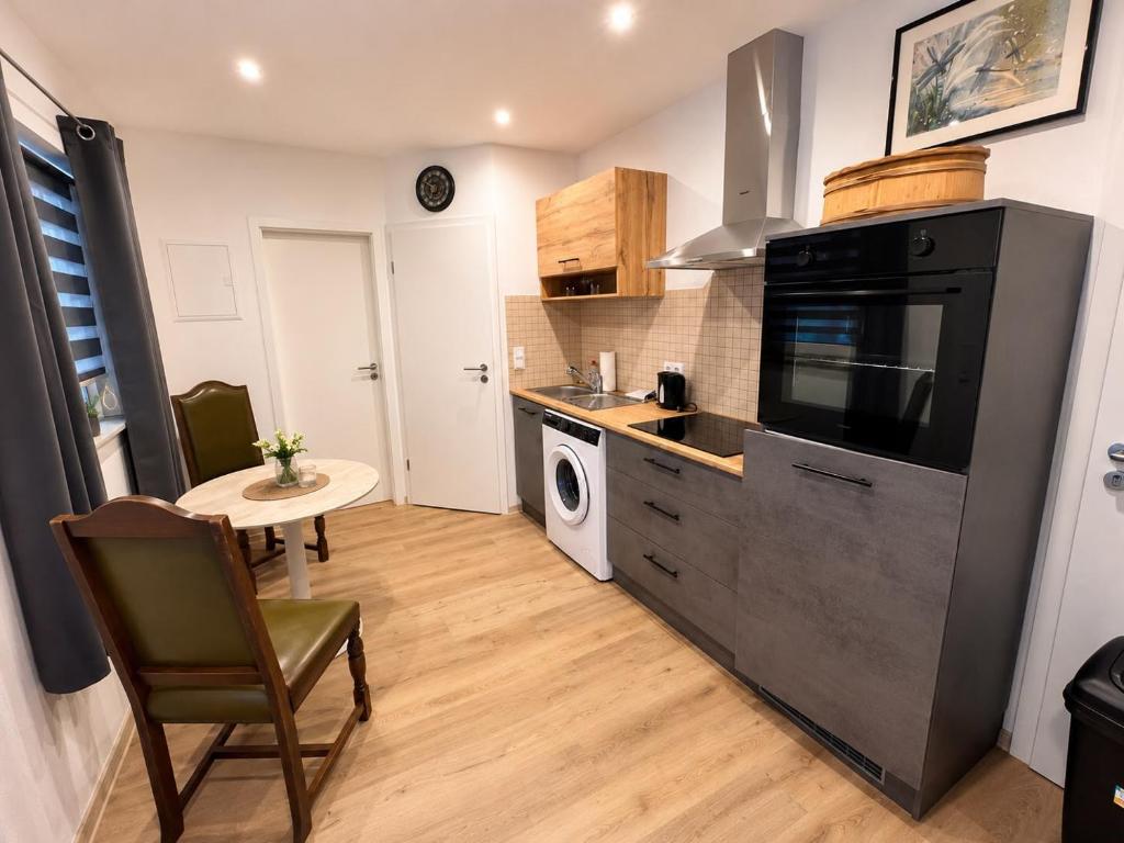 a kitchen with a black refrigerator and a small table at Rent Room Vermietungen in Oberhausen