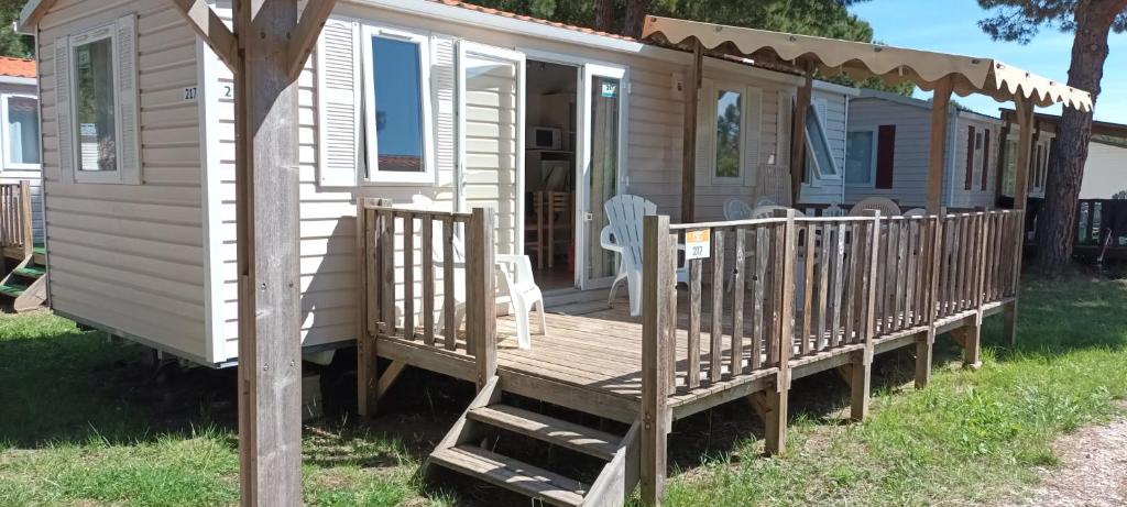 a mobile home with a porch and a deck at Mobilhome 217 in Torreilles