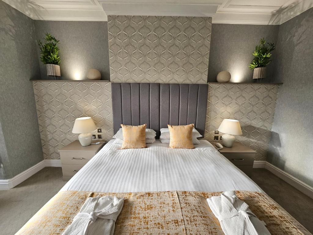 a bedroom with a large bed and two lamps at Bedford Hotel in Lytham St Annes
