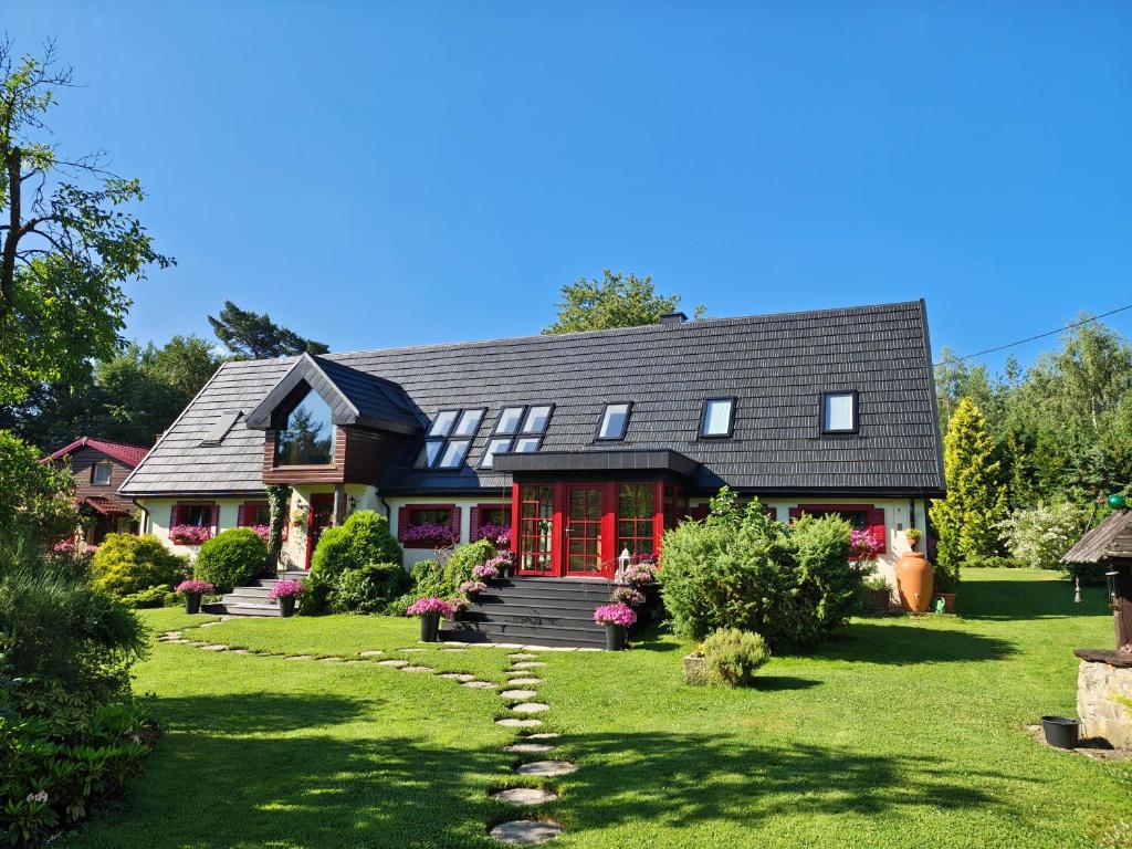a large house with red doors and a yard at U Helci - Na Krańcu Świata - Azyl tylko dla Dorosłych in Studzienno