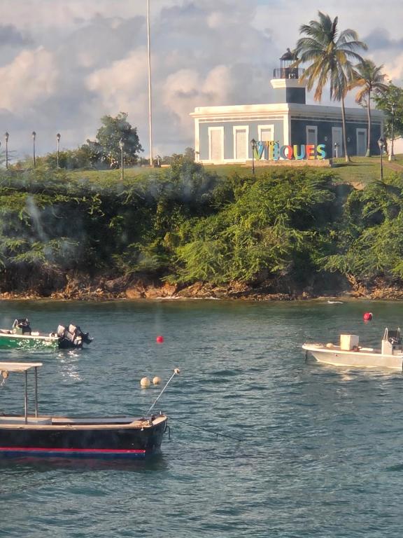 two boats in the water with a building in the background at Pilot Glamp in Vieques