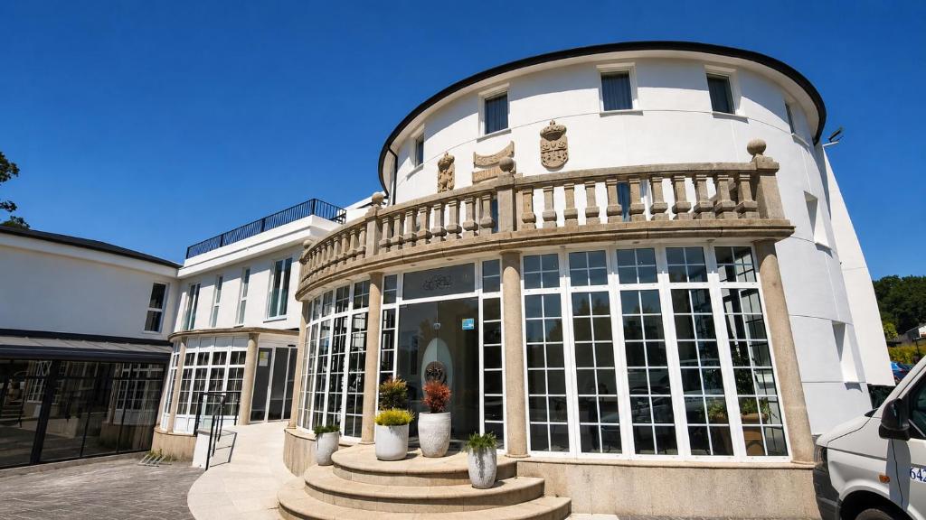 a white building with a balcony on top of it at Hotel La Palloza in Lugo