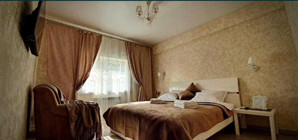 ein Schlafzimmer mit einem Bett, einem Stuhl und einem Fenster in der Unterkunft Rest 33 in Odessa