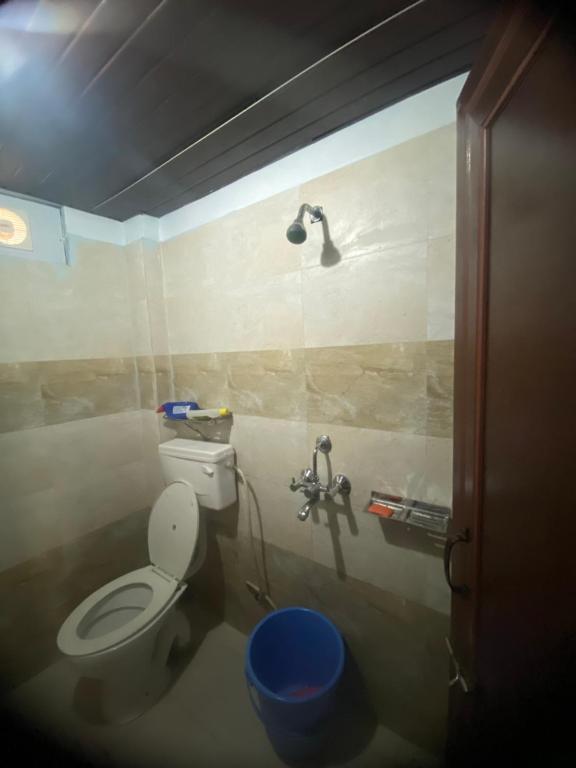 a bathroom with a toilet and a shower at Pahari Trekkers in Nainital