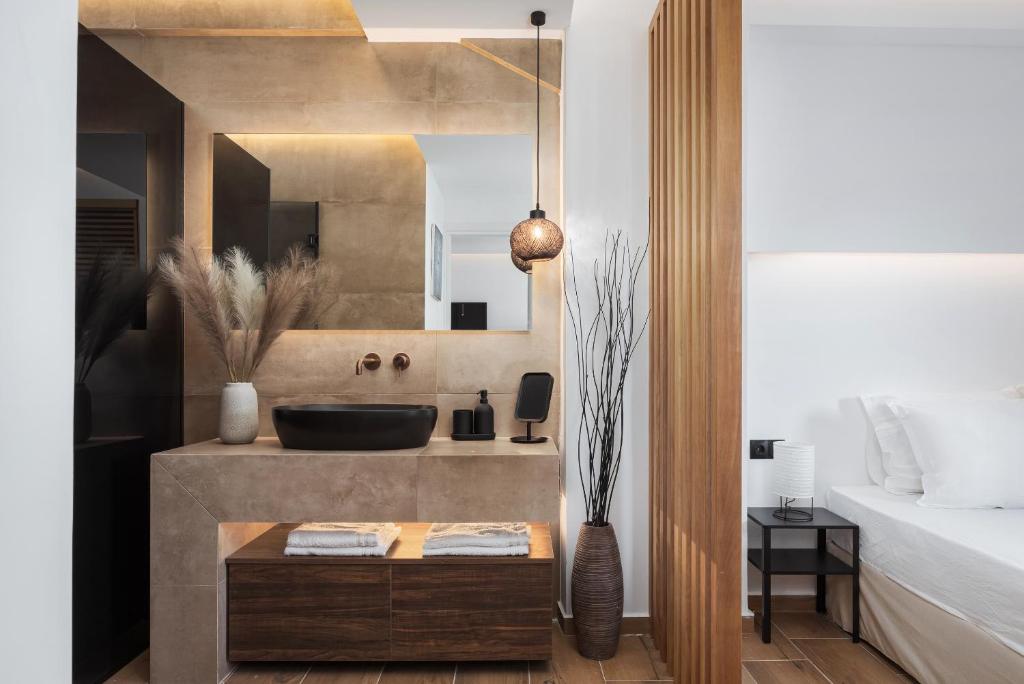 a bathroom with a sink and a bed at Vouliagmeni Olivomare Suite in Athens