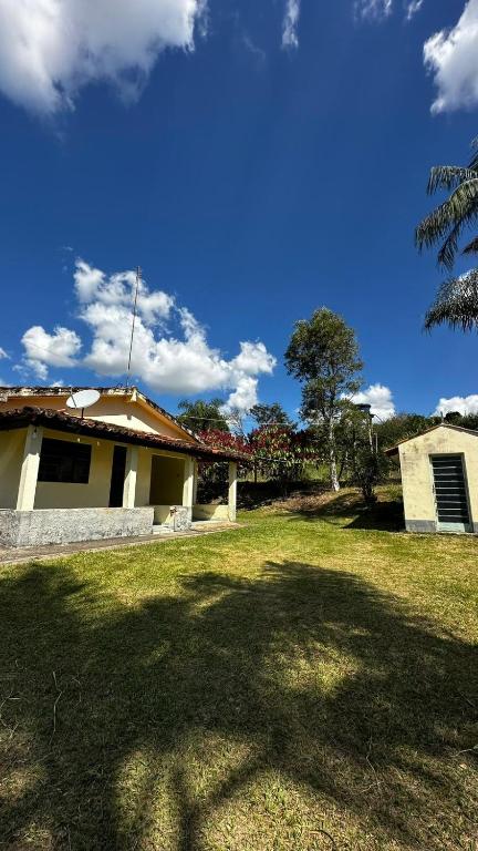 a house with a grass yard next to a building at Recanto 2 irmãos in Socorro