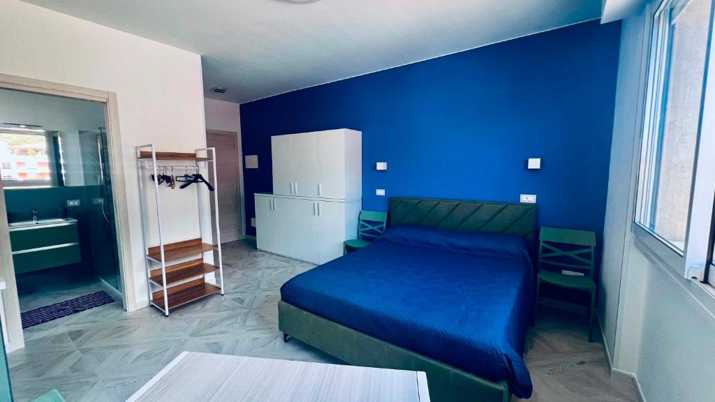 a bedroom with a bed and a blue wall at Casa di Bea 2 in Ventimiglia