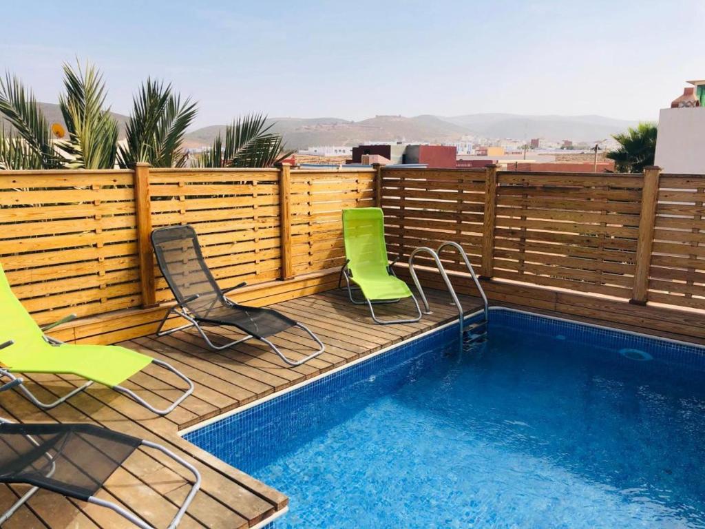 a deck with two chairs and a swimming pool at Villa Azal in Mirleft
