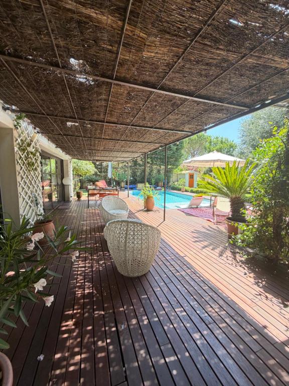 a patio with a table and chairs and a pool at Maison AdriAnna in Vedène