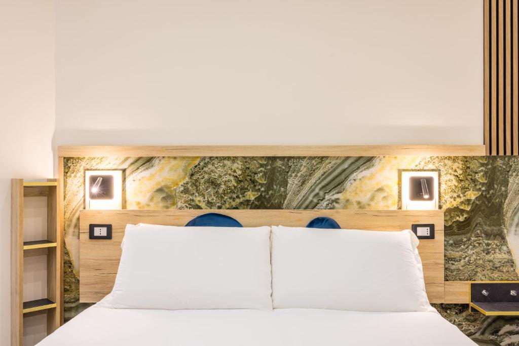 a bedroom with a white bed and a painting on the wall at Bologna Rooms in Naples