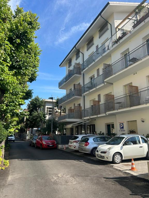 a parking lot with cars parked in front of a building at Residence Abamar in Rimini