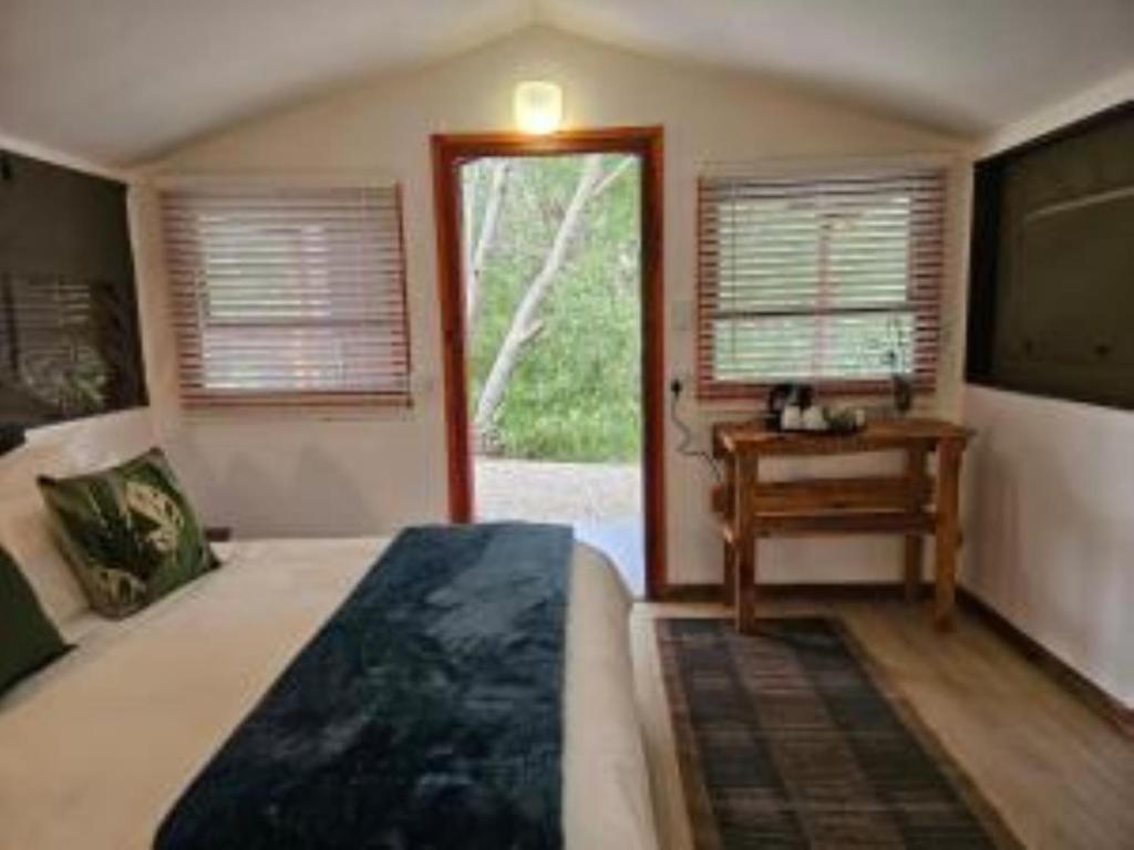 a bedroom with a bed and a table and a window at The Lineage Lodge in Elgin