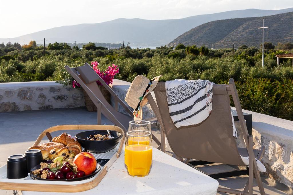 a table with a tray of food and a glass of orange juice at Argolis Rodies Homes in Kilada