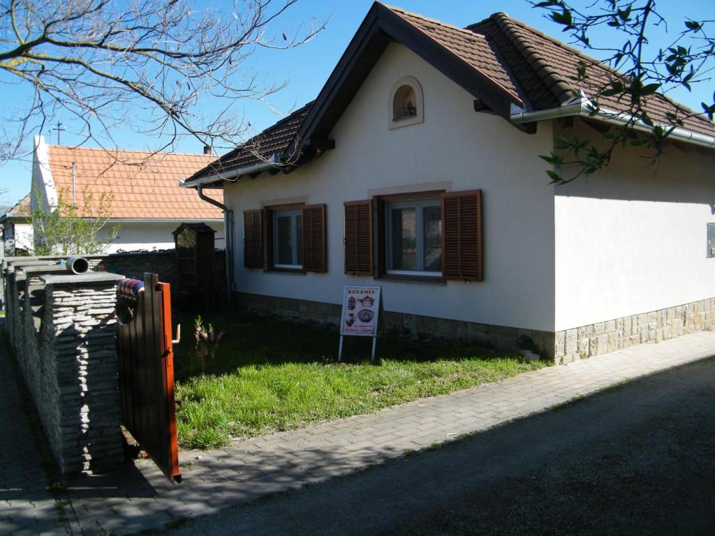 a white house with a sign in front of it at Sártekerő Vendégház in Alsópáhok