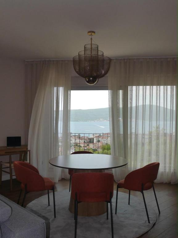 a living room with a table and chairs and a window at Apartment Marta Tivat in Tivat